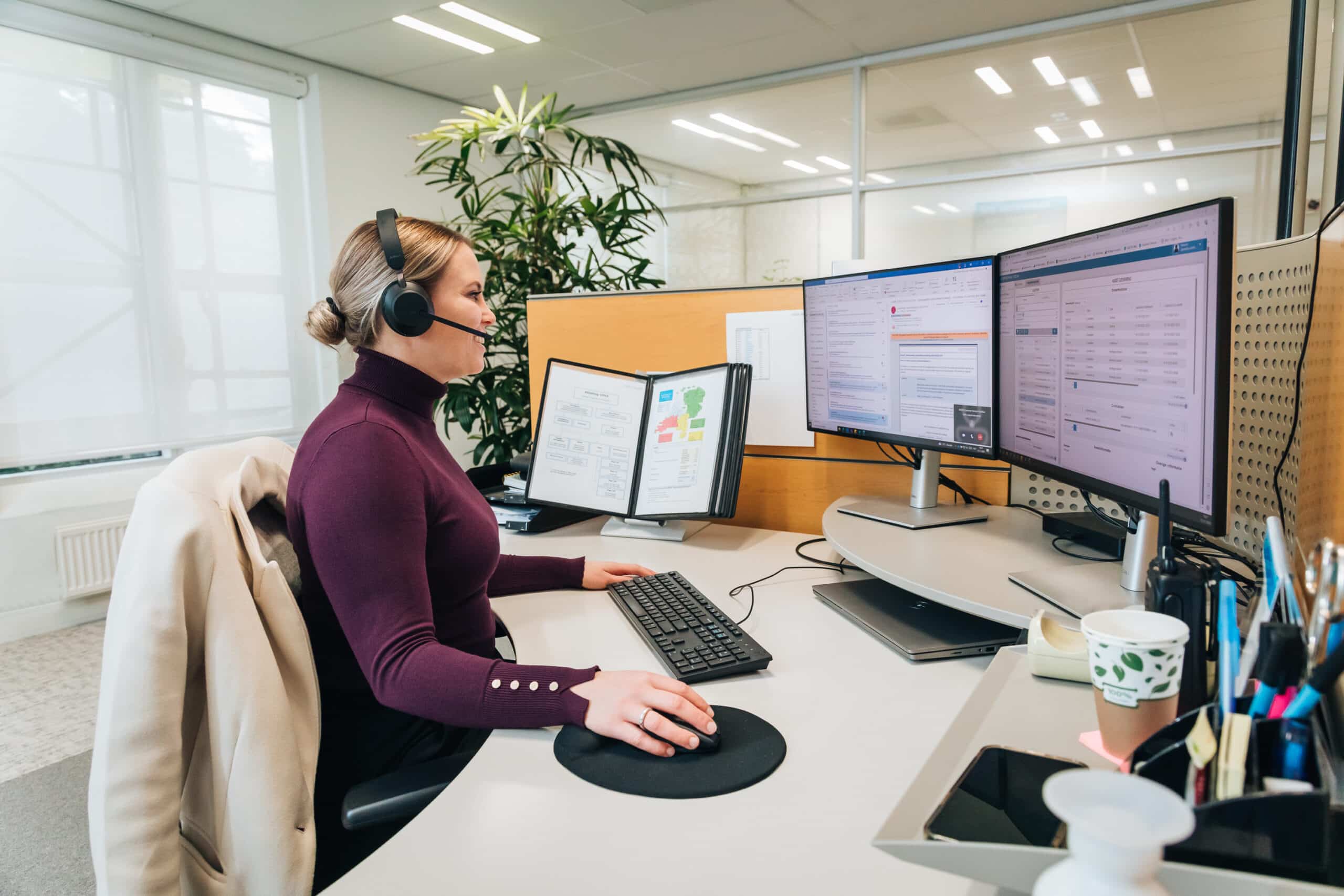 Vrouwelijke collega met headset achter bureau