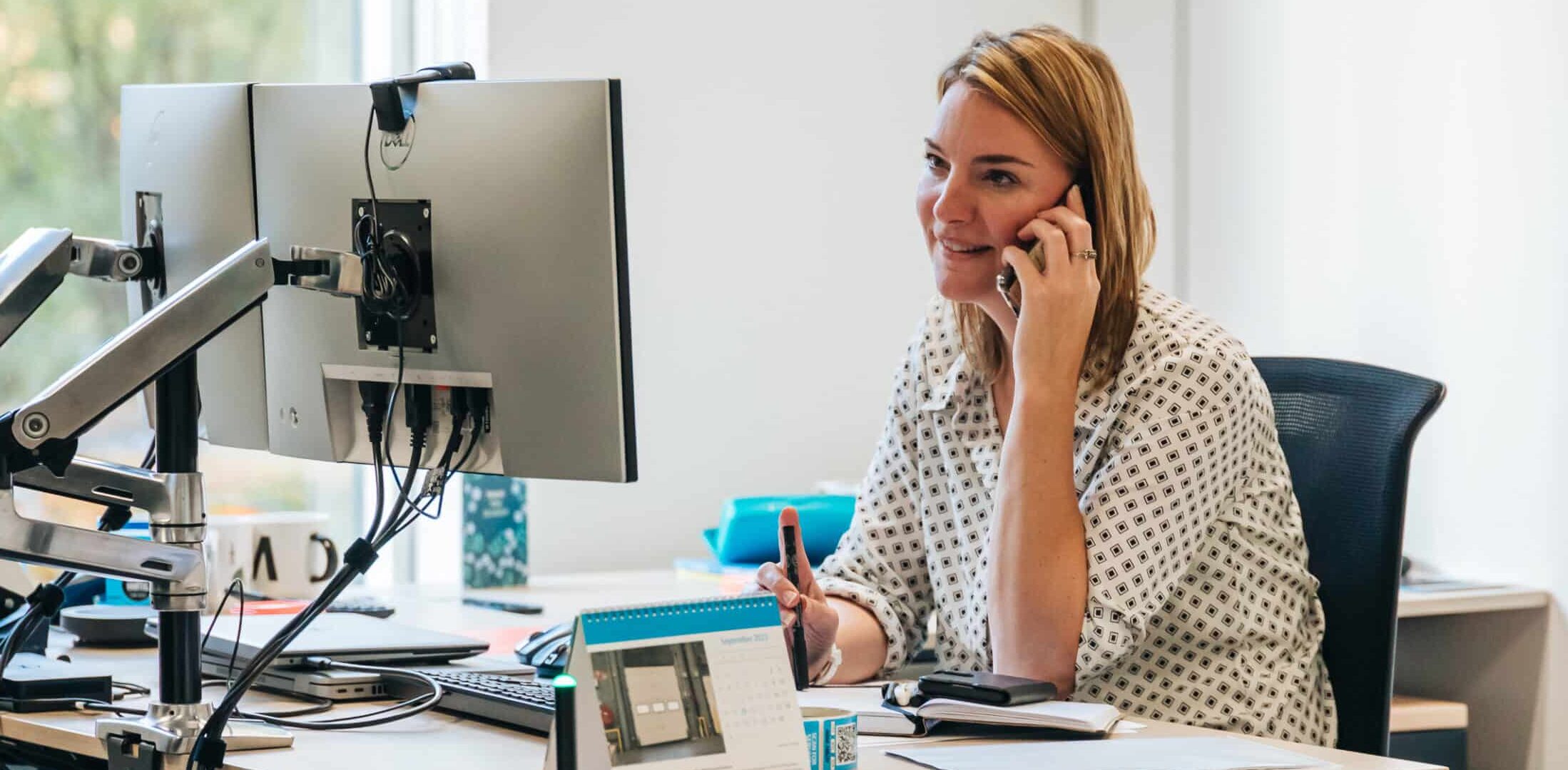 Vrouw bellend achter de computer