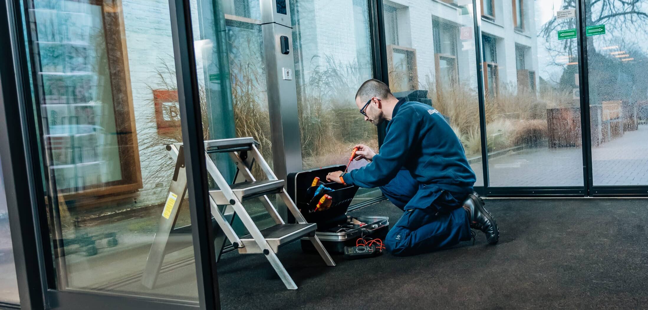 Monteur bij de deur pakt iets uit gereedschapskist